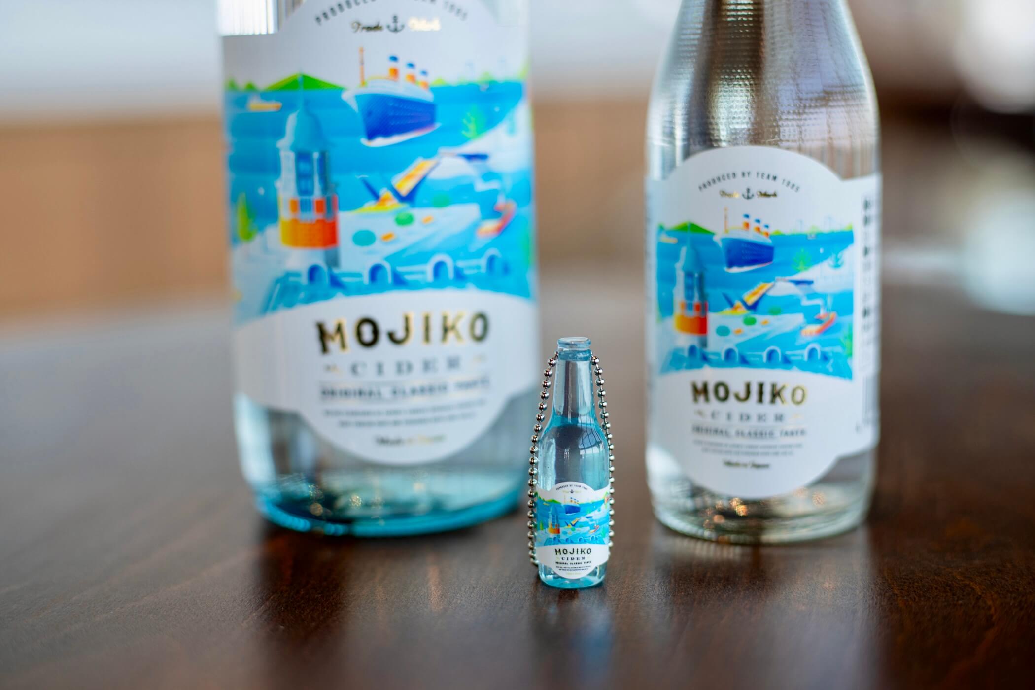 門司港サイダーのボトルを背景にしたミニチュアキーホルダー