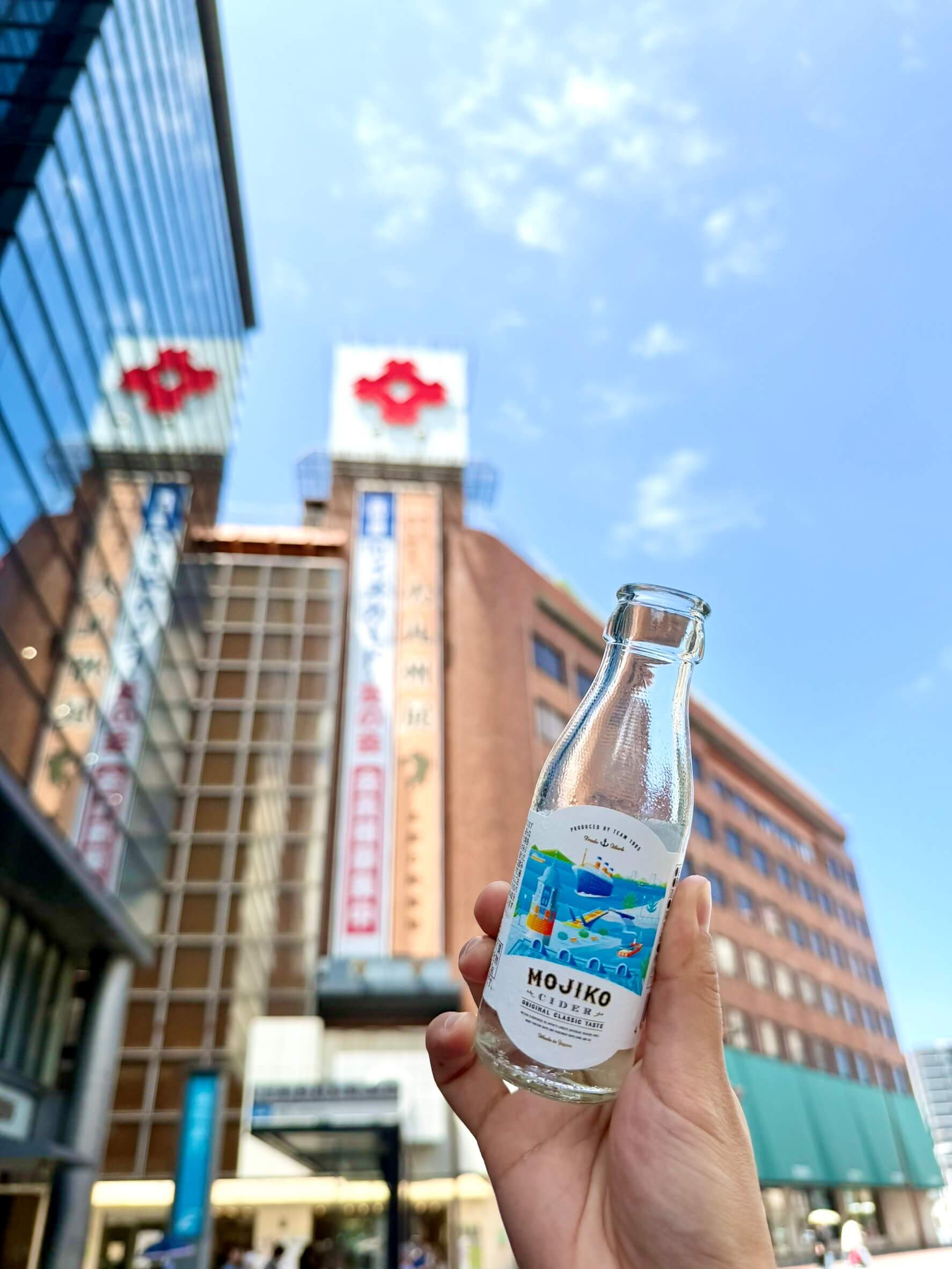 小倉井筒屋を背景に門司港サイダーMINI